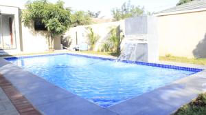 een zwembad met een waterval in een huis bij Royal relax guest house in Palatswe +16 foto's