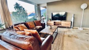 uma sala de estar com um sofá e uma televisão em Lakeview Little House em Krattigen