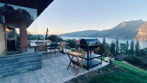 a patio with a grill and a view of the water at Lakeview Little House in Krattigen