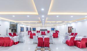 a banquet hall with red and white tables and chairs at Mithila Yatri Niwas in Janakpur