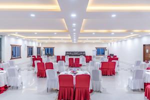 un salón de banquetes con mesas y sillas rojas y blancas en Mithila Yatri Niwas en Janakpur