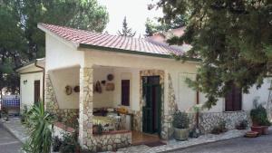 une petite maison blanche avec un toit rouge dans l'établissement Villa Sarmuci, Mare Natura Relax, à Scopello