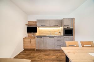 a kitchen with stainless steel appliances and wooden floors at Parigger Apt Lavendel in Racines