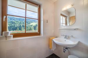 a white bathroom with a sink and a window at Parigger Apt Zirbe in Racines