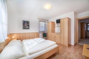 a bedroom with a large white bed and a desk at Parigger Apt Zirbe in Racines