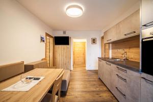 a kitchen with a wooden table and a wooden floor at Parigger Apt Enzian in Racines
