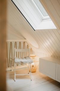 a skylight in a attic with a white chair at ALNUS KIEMAS in Kampiškiai