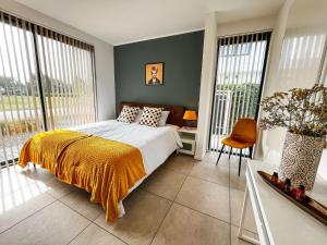 um quarto com uma cama com um cobertor amarelo em Luxury holiday home in Zeewolde with garden and bubble bath em Zeewolde