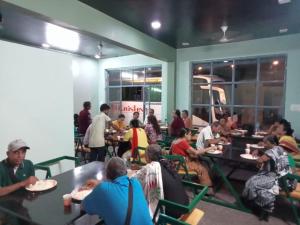 Hotel Sunrise Palace في أودايبور: مجموعة من الناس يجلسون على الطاولات في المطعم