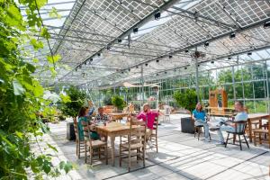 a group of people sitting at a table in a greenhouse at Achterhoeks Goed in Lichtenvoorde-Vragender in Vragender
