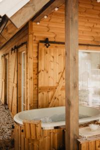 uma casa de banho em madeira com uma banheira num quarto em ALNUS KIEMAS em Kampiškiai