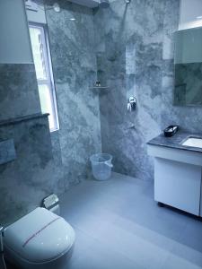 a bathroom with a toilet and a sink at Golden Peaks Hotel & Restaurant in Kalimpong