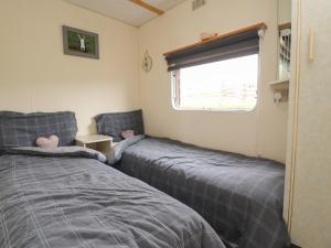 two beds in a small room with a window at Hillcrest Croft in Preston