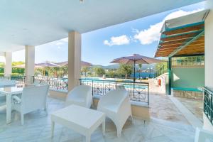 une terrasse avec des tables et des chaises ainsi qu'une piscine dans l'établissement St Nicholas A1 Beach Superior Two I, à Dafnila