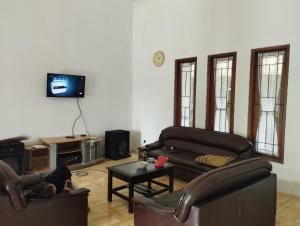 uma sala de estar com dois sofás e uma televisão em Villa bhifa Puncak em Bogor
