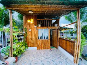 a wooden house with a balcony with plants at Joyful Hut with Netflix and Perfect Sunrise View Maya, Daanbantayan 