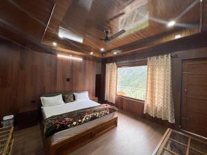 a bedroom with a bed and a window in a boat at Ramneek Homestay in Joshīmath