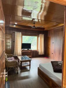 a bedroom with a bed and a tv and a table at Ramneek Homestay in Joshīmath