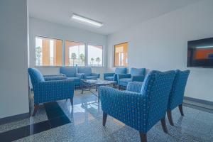 una sala de espera con sillas azules y una mesa en Island Inn By OYO Galveston Beach, TX en Galveston