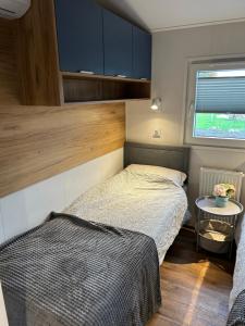 um pequeno quarto com uma cama e uma janela em Ferienhaus Feldblick em Fehmarn