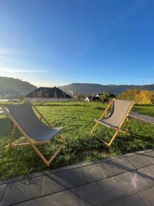 deux chaises assises sur l'herbe dans un champ dans l'établissement Ferienwohnung Biedenkopf, à Biedenkopf