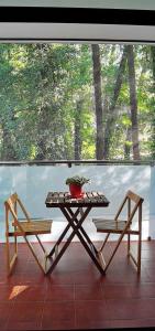 une table et deux chaises assises sur une terrasse couverte dans l'établissement APARTAMENTO ALES, à Arenas de San Pedro