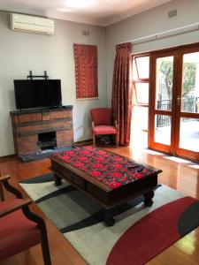 a living room with a coffee table in front of a fireplace at Muckleneuk Guest House in Pretoria