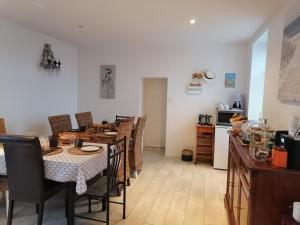 a dining room with a table and chairs and a kitchen at La Longère des Olonnes in Les Sables-d'Olonne
