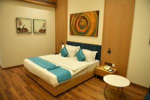 a hotel room with a bed with a table and a table at Hotel Blueivy Anand in Anand
