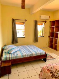 1 dormitorio con 1 cama y 2 ventanas en Loft NOA'House en Canoa Quebrada