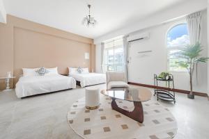 een slaapkamer met 2 bedden en een glazen tafel bij Knock Knock Style Inn in Taitung