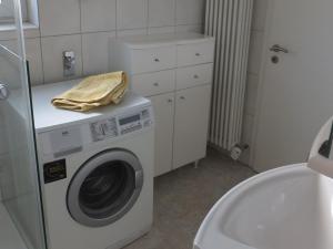 een wasmachine met een gele handdoek erop bij Haus Alpenblick in Immenstaad am Bodensee