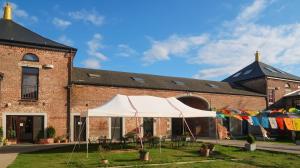 een witte tent voor een bakstenen gebouw bij Dharma City in Florennes