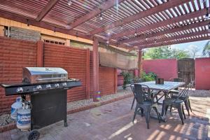 a patio with a grill and a table and chairs at Stylish Tucson Home Backyard Oasis with Grill! in Tucson