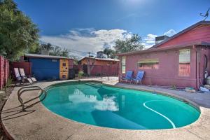 a swimming pool with two chairs and a house at Stylish Tucson Home Backyard Oasis with Grill! in Tucson