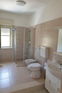 ein Bad mit einem WC, einem Waschbecken und einer Dusche in der Unterkunft Appartamento Marchese in Racalmuto