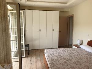ein Schlafzimmer mit einem Bett und einem großen weißen Schrank in der Unterkunft Appartamento Marchese in Racalmuto