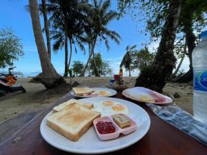 a plate of breakfast food on a table at the beach at Koh Mak Green View Resort in Ko Mak