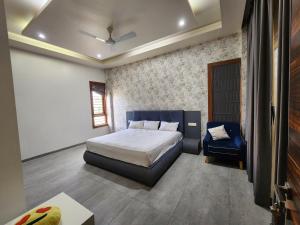 a bedroom with a bed and a blue chair at House 40 - Strictly Parties and Noise not allowed, read house manual before booking in Pune