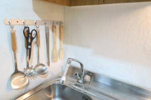 a kitchen sink with utensils hanging on a wall at appartamento Artesina in Sella della Turra