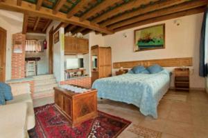 ein Schlafzimmer mit einem Bett und ein Wohnzimmer in der Unterkunft Apartamento rural El Pastor es un estudio con gran ventanal a Gredos in Cabezas Bajas