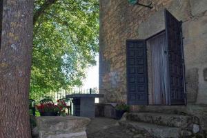 una entrada a un edificio con una puerta y un banco en La Torre del Molino es una casa rural ubicada sobre un antiguo molino en Tormellas