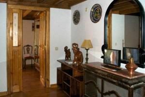 sala de estar con escritorio, espejo y lámpara en La Torre del Molino es una casa rural ubicada sobre un antiguo molino en Tormellas