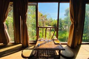 a room with a table and a large window at HappyZen Farm in Vung Tau