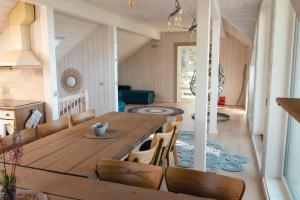 a kitchen and dining room with a wooden table and chairs at Villa of Nature Energy on Prangli island in Kelnase