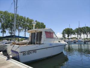 een witte boot is aangemeerd bij een dok bij Nuit insolite sur l'eau au port de Ouistreham in Ouistreham