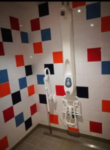 La salle de bains est pourvue d'un urinoir sur un mur coloré. dans l'établissement Nuit insolite sur l'eau au port de Ouistreham, à Ouistreham