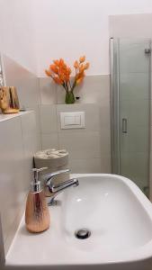 un lavabo con un grifo y flores. en Aurum Apartment, en Kirchheim am Neckar