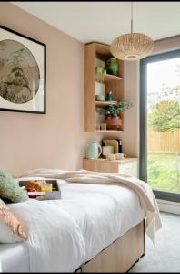 a bedroom with a bed with a tray of food on it at Travellers Tales - A Pod in the Cotswolds in Minster Lovell