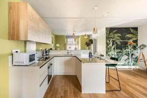 a kitchen with white cabinets and a microwave at Shamrock, Bowness on Windermere, Superb one bedroom apartment with private parking in Bowness-on-Windermere